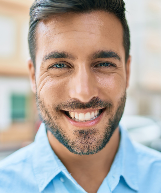 Junger Mann mit Bart lächelt